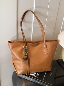Minimalist brown leather tote bag with tassel charm for daily commute fashion