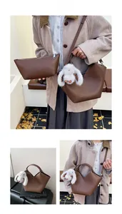 Vue détaillée du sac seau en cuir marron foncé avec un petit charme de lapin en peluche