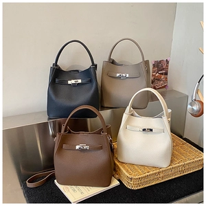 Detail of four bucket bags in litchi grain leather with silver metal lock closure