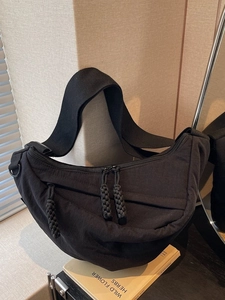 Large black nylon crescent crossbody bag with woven zip pullers for casual commute