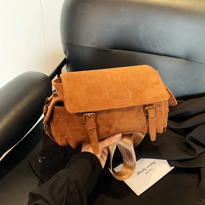 Brown faux suede crossbody bag with vintage buckle straps and wide shoulder strap