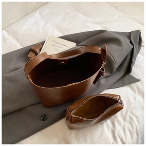 Deep brown bucket bag set with matching pouch on grey blazer, stylish commuter handbag