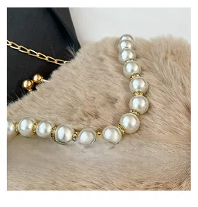 Détail d'un collier de perles élégant avec des séparateurs dorés sur fond en peluche