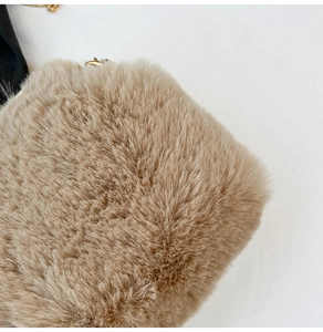 Détail de la texture en fausse fourrure beige et chaîne en métal doré du sac