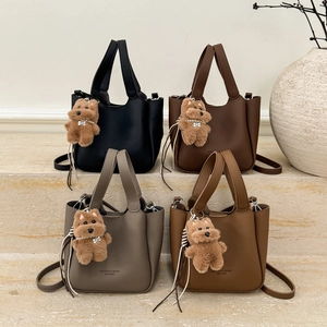Minimalist leather bucket bags in four colors with teddy bear charms and shoulder straps