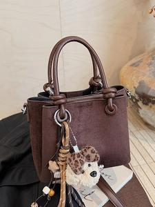 Brown faux suede bucket bag with decorative knot handle and cute plush puppy charm