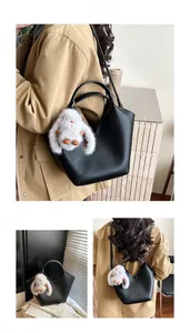 Sac seau noir en cuir grainé avec charm lapin blanc et bandoulière amovible