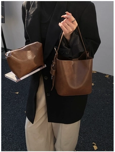 Caramel leather hobo bag and matching pouch set with a polished texture and sleek handles