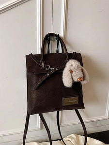 Retro dark brown leather backpack with silver metal plate and white rabbit doll accessory
