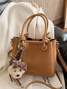 Brown suede bucket bag with top handles and a cute plush puppy pendant for casual wear
