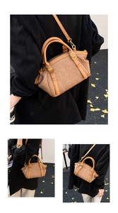 Detail of woven fabric crossbody bag with brown leather trim and golden metal buckles