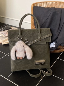 Olive green vintage tote backpack with plush rabbit charm and silver metal logo