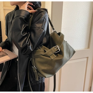 Detail of olive green leather motor bag with large buckle and adjustable shoulder strap