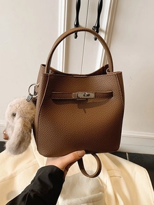 Brown lychee leather bucket bag with retro metal buckle and plush charm detail