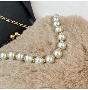 Détail de bandoulière en perles avec entretoises dorées en strass sur peluche
