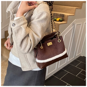 Detail of dark brown suede handbag featuring quilted leather base and white faux fur trim