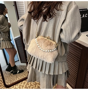 Détail du sac coquille en peluche avec chaîne en perles et fermoir en métal vintage