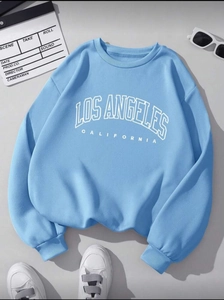 Detailed flat lay of light blue crewneck sweatshirt with Los Angeles typography design