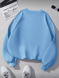 Flat lay of sky blue crew neck sweatshirt with elastic ribbed cuffs and dropped shoulders