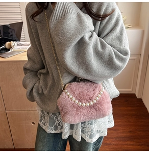 Détail du sac en peluche rose avec poignée en perles et bandoulière en métal doré