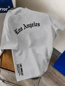 Nahaufnahme des gotischen Los Angeles Buchstabendrucks auf grauem Baumwoll-T-Shirt