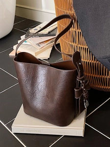 Vintage brown leather tote bag with stylish bow accent and metallic lock detail