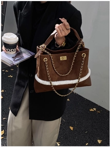 Detail of vintage suede hobo bag with quilted stitching and white faux fur trim and gold chain