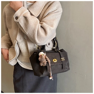 Detail of vintage brown crossbody bag with matte leather and teddy bear charm