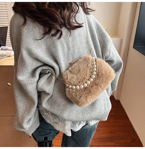 Détail du sac en peluche avec poignée en perles et bandoulière en chaîne dorée élégante