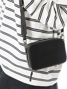 Minimalist black rectangular crossbody camera bag with adjustable strap on model