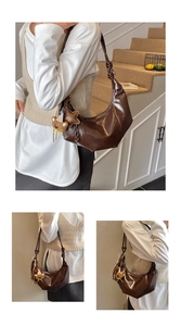 Detail der dunkelbraunen Hobo-Tasche mit geknotetem Gurt und süßem Bärenanhänger