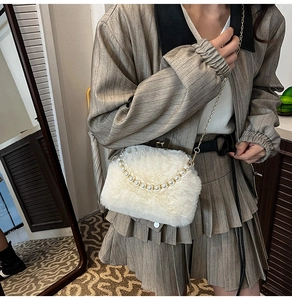 Détail d'un sac bandoulière en fausse fourrure blanche avec chaîne perlée et dorée
