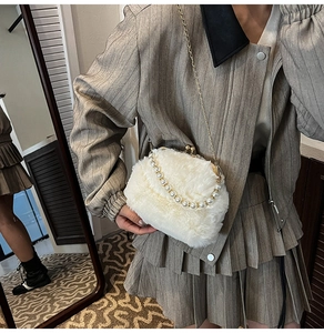 Détail du sac coquillage en peluche blanche avec poignée en perles et chaîne dorée