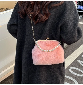 Détail du sac coquillage en peluche rose avec anse perlée et chaîne dorée sur un modèle