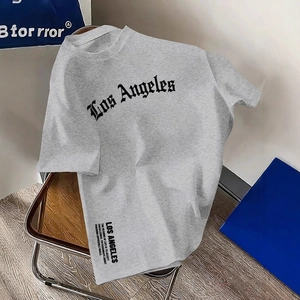 Graues Baumwoll-T-Shirt mit Los Angeles Print und Motivationsspruch auf einem Stuhl