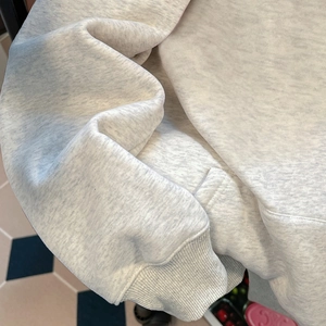 Gros plan d'un sweat à capuche vintage gris avec poignets côtelés et texture polaire épaisse