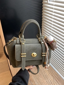 Olive green vintage crossbody bag with gold hardware and a cute capybara keychain charm