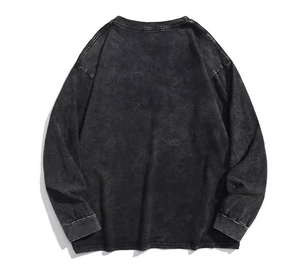 Detailed view of washed grey cotton T-shirt featuring ribbed cuffs and vintage texture