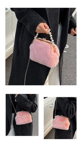 Detail van roze pluche schelptas met parelhandvat en een gouden metalen schouderketting