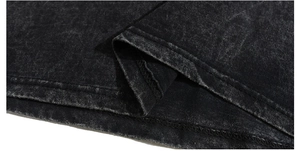 Macro detail of charcoal wash cotton fabric showing snow-wash texture and double stitching