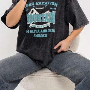 Oversized acid wash black T-shirt with vintage mountain print and denim jeans