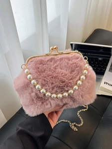 Sac coquillage en peluche rose avec poignée en perles et chaîne en métal en situation