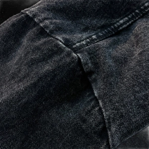 Detail of vintage charcoal grey washed cotton long sleeve T-shirt with double-stitched seams