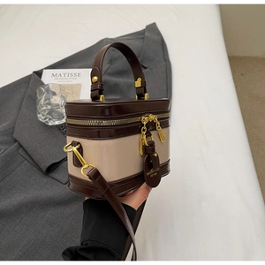 Detailansicht einer zweifarbigen Vintage-Box-Tasche mit Tragegriff und Gold-Reißverschluss