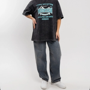 Oversized washed grey T-shirt with blue vintage print on studio background