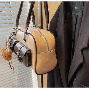 Detail of retro Boston tote bag with cream PU leather and brown trim featuring a plush bear