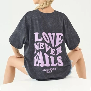 Detail of Love Never Fails print on heavy acid wash dark grey oversized cotton t-shirt