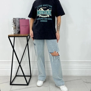 Detailed view of oversized vintage washed black graphic t-shirt and ripped denim jeans