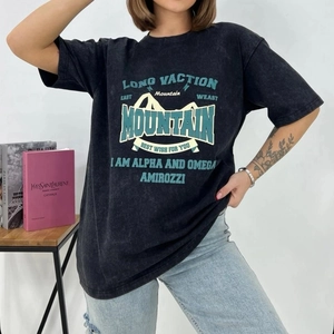 Detail of vintage washed black oversized t-shirt with Mountain graphic print on a model