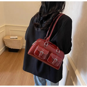 Detail of burgundy bowling bag featuring white contrast stitching and twin front flap pockets